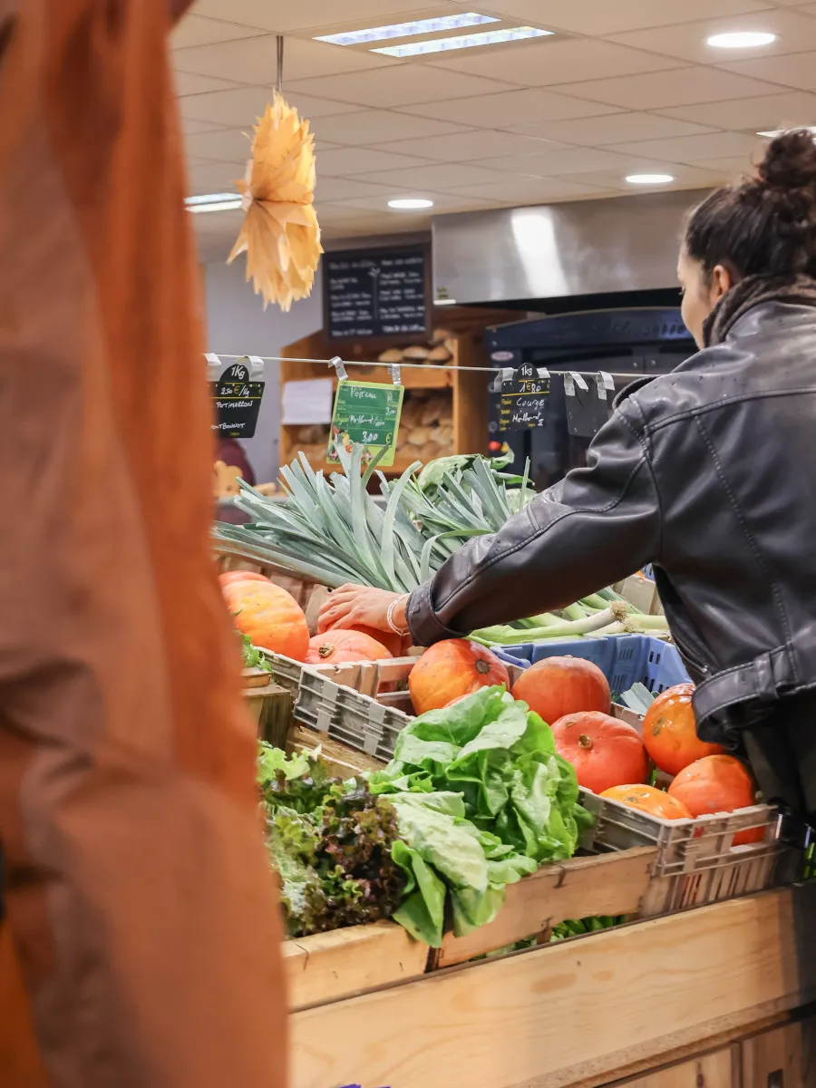 Une cliente choisit ses légumes sur l&rsquo;étal
