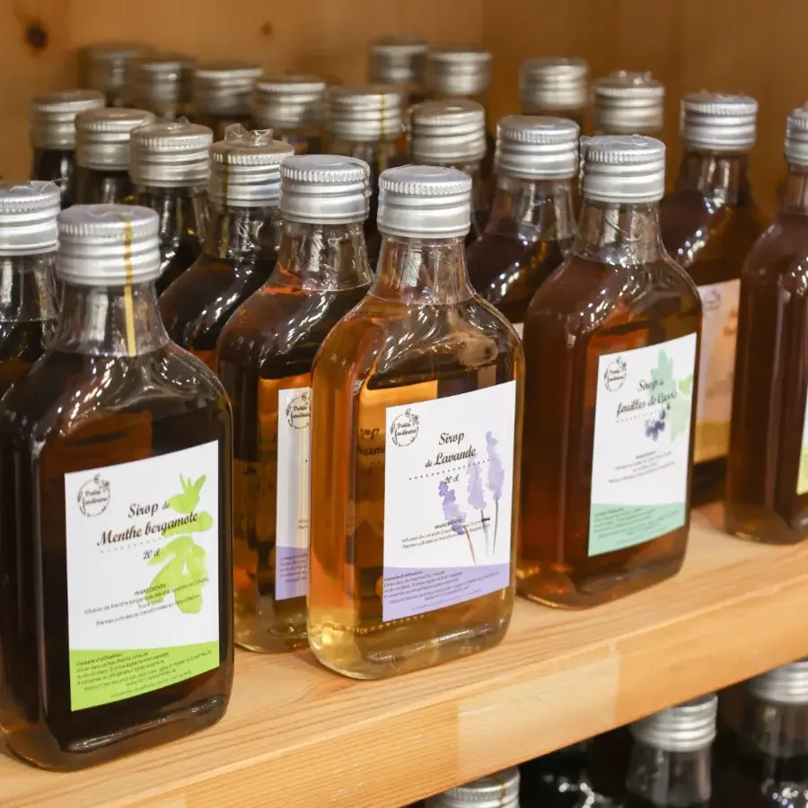 Bouteilles de jus de fruits et sirops sur une étagère en bois