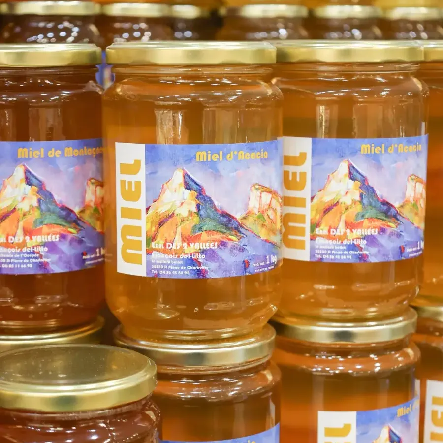 Des pots de miel de montagne alignés sur une étagère